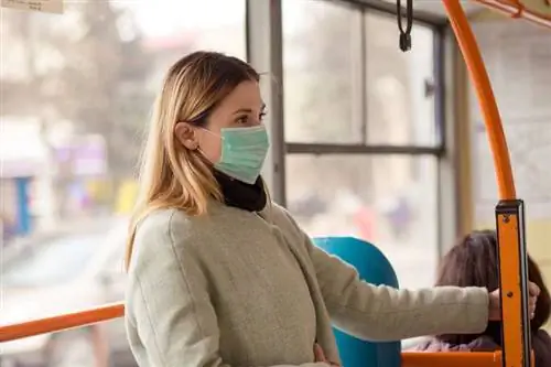 Женщина в защитной маске в автобусе Женщина в защитной маске в автобусе