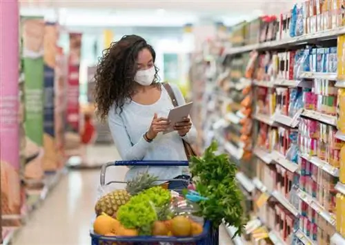 Молодая женщина ходит по магазинам со списком покупок