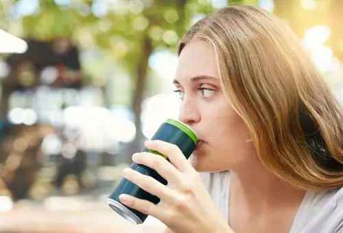 Женщина пьет из банки