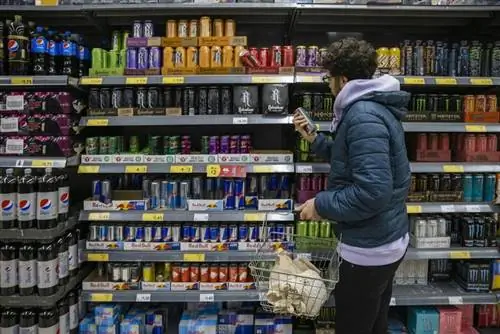Мужчина покупает энергетические напитки в супермаркете Мужчина покупает энергетические напитки в супермаркете