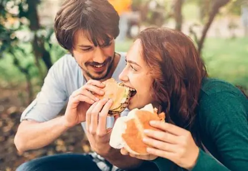 Пара ест гамбургеры