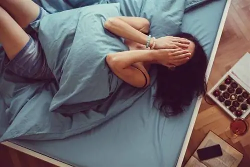 Женщина прячет руки в лицо