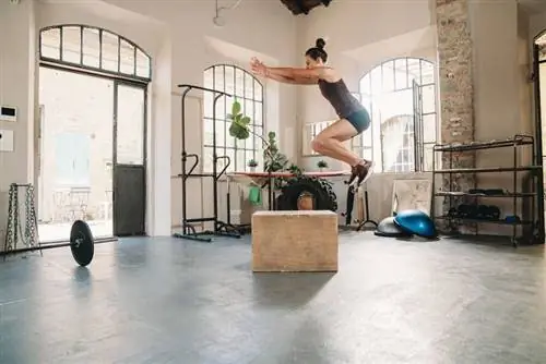 Женщина прыгает на ящике в спортзале