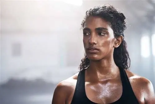 Женщина потеет во время тренировки