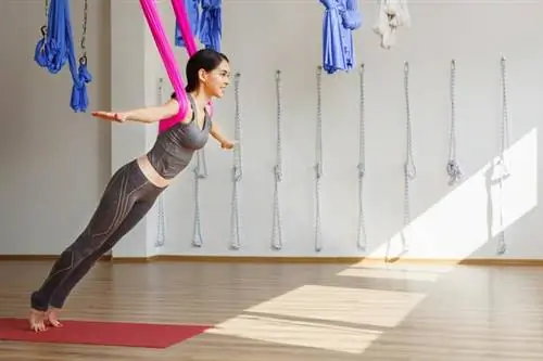 Женщина занимается воздушной йогой