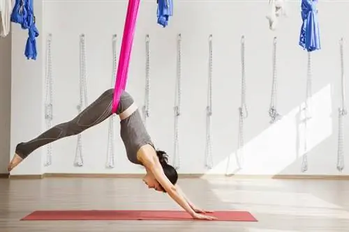 Женщина занимается воздушной йогой