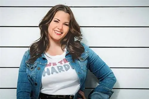 Женщина с вьющимися длинными волосами и джинсовой жилеткой