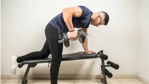 мужчина неправильно выполняет тягу гантелей