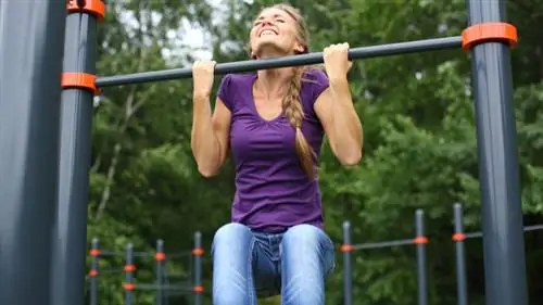 человек на открытом воздухе изо всех сил пытается выполнить подтягивания
