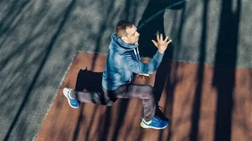 Мужчина выполняет выпад на улице