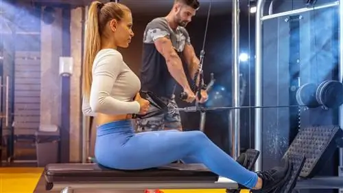 Женщина выполняет упражнения на канате в спортзале