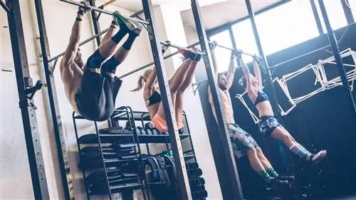 Группа людей, выполняющих упражнения на перекладине в тренажерном зале