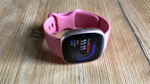 Fitbit Versa 4 под углом, показывает кнопку