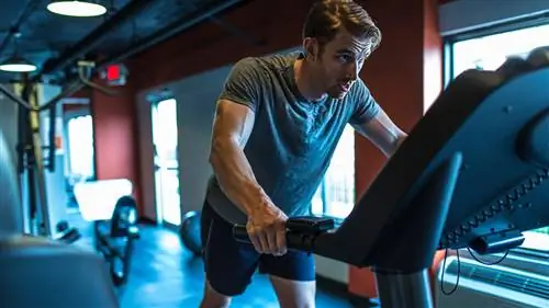 Мужчина отдыхает после тяжелого бега на беговой дорожке