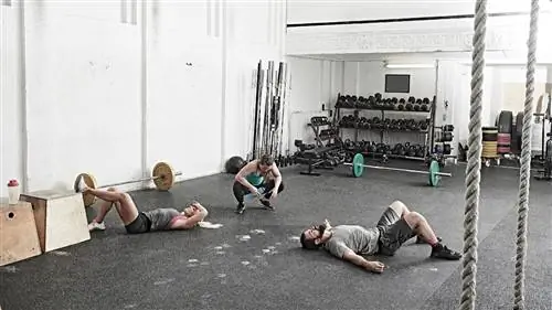 Люди отдыхают на полу спортзала