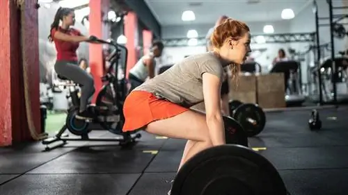 Женщина выполняет становую тягу