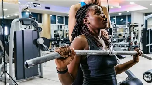 Женщина выполняет тягу вниз