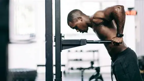 Мужчина выполняет упражнения на трицепс с помощью брусьев в тренажерном зале