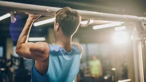 Мужчина выполняет подтягивание молотком