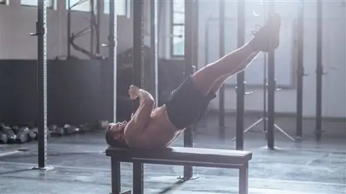 Мужчина выполняет упражнение с флагом дракона в спортзале