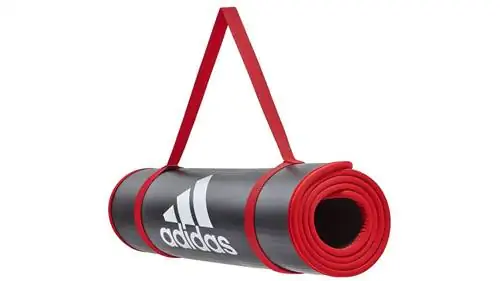 Тренировочный коврик Adidas в свернутом виде с ремнем.