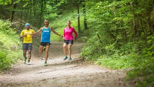 Хайден Хоукс и двое других бегунов бегут вниз по склону. Хоукс широко раскинул руки