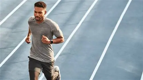 Мужчина на беговой дорожке с фитнес-трекером Fitbit Versa 2