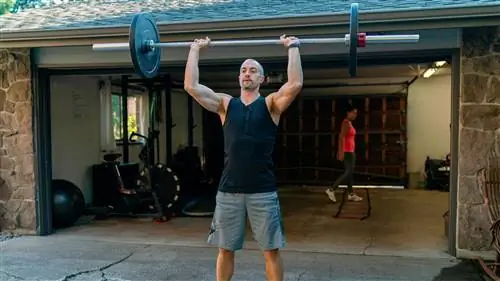 Мужчина выполняет жим со штангой над головой